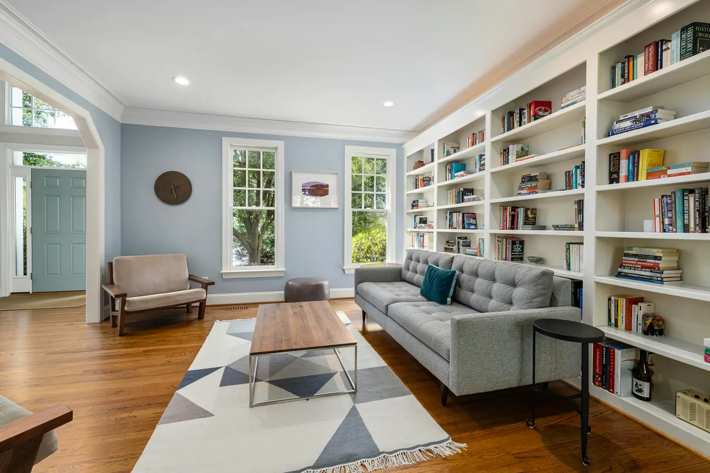 A bright living room with built-in bookshelves and a grey sofa